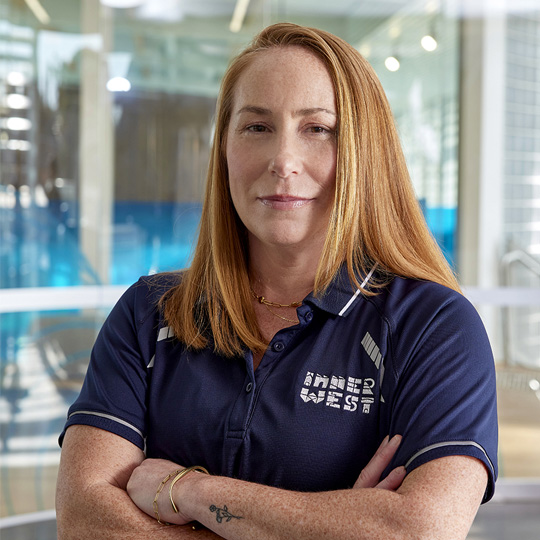  Personal trainer Kate smiling at the camera with arms crossed wearing a navy Inner West Council branded shirt